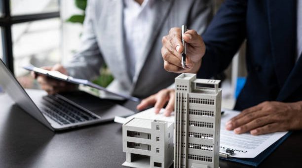 real estate agent Describe house designs to view house plans and purchase contracts. wooden house at modern office ​​Business success, signing a contract to buy a house with land and insurance with the concept of renting a house